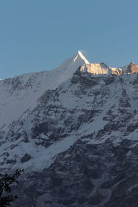 Scenic view of snowcapped mountains against clear blue sky