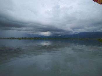 Scenic view of lake against cloudy sky