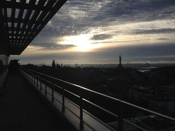 Bridge in city against sky during sunset