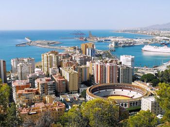 High angle view of buildings by sea against clear sky