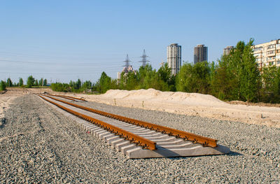 View of railroad tracks by building against clear sky