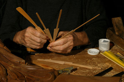 Carpentry craftsman's hands building a fan, unrecognisable.