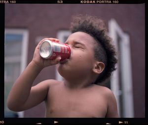 Close-up portrait of boy holding camera