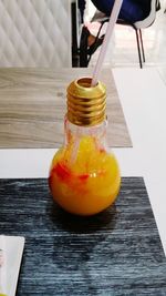 Close-up of hand holding drink in jar on table