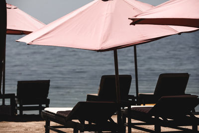 Empty chairs and table against sea