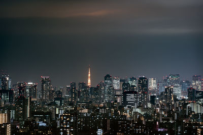 Illuminated cityscape against sky at night