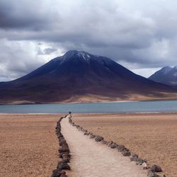 Scenic view of lake and mountains against cloudy sky