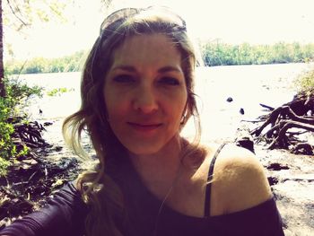 Portrait of smiling young woman against sky