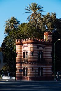 Low angle view of palm trees and building against sky