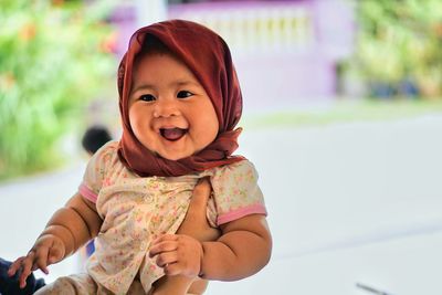 Cropped hand holding happy baby girl