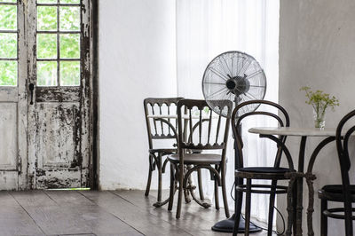 Empty chairs and table against building