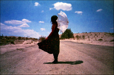 Full length of woman standing on land against sky