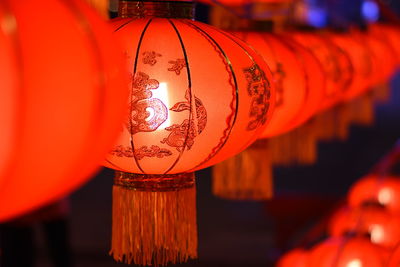 Illuminated lanterns hanging in row