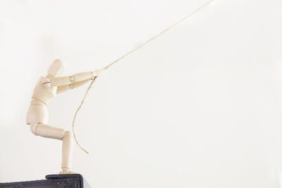 Close-up of hand holding umbrella against white background