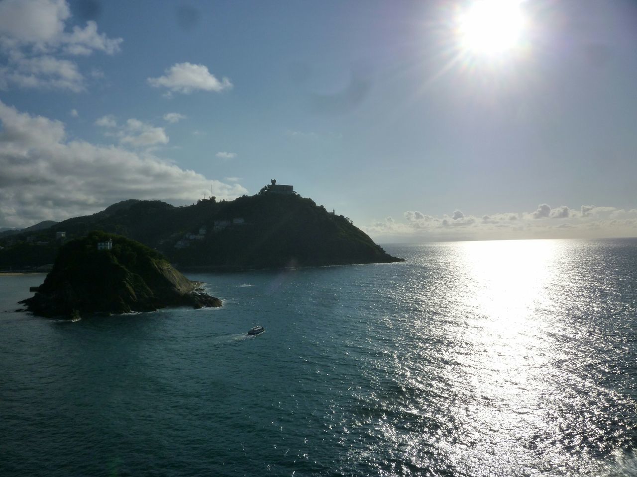 sun, water, sea, tranquil scene, scenics, tranquility, sunlight, sky, beauty in nature, sunbeam, horizon over water, waterfront, reflection, lens flare, nature, rippled, idyllic, silhouette, mountain, rock - object