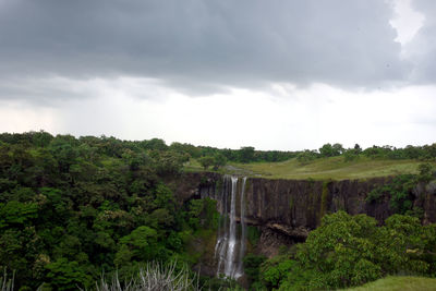 Scenic view of waterfall against sky