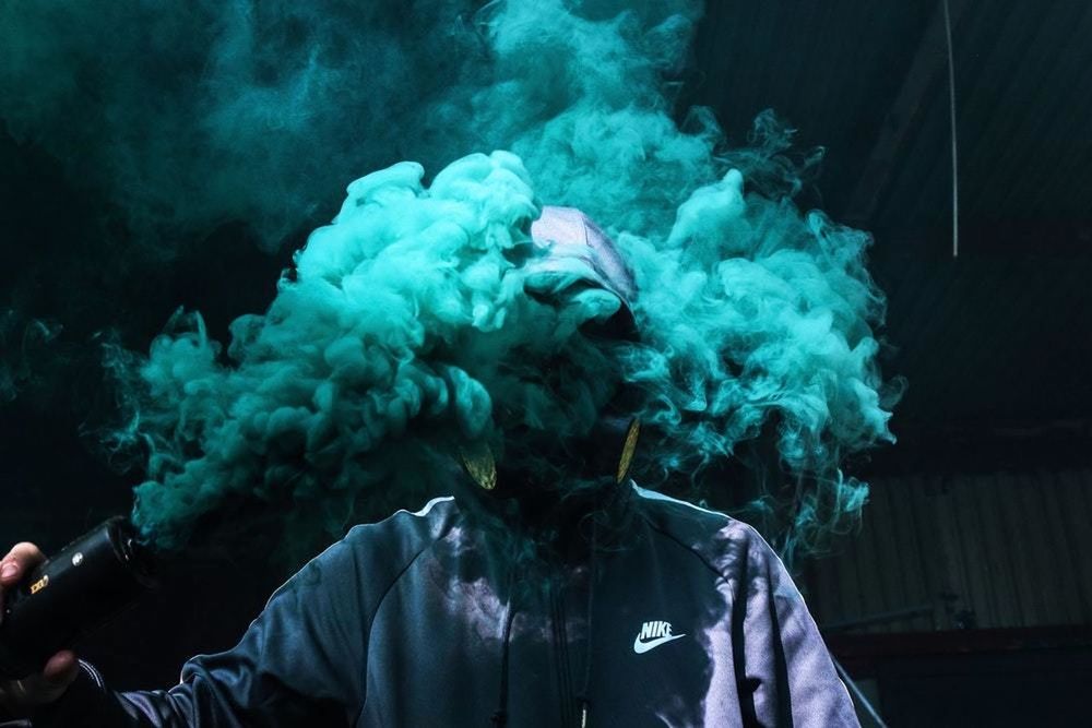 smoke - physical structure, one person, real people, headshot, leisure activity, bad habit, lifestyles, portrait, men, smoking issues, front view, motion, social issues, clothing, activity, obscured face