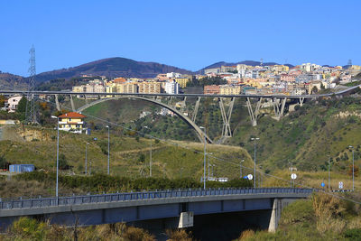 Arch bridge in city against clear blue sky