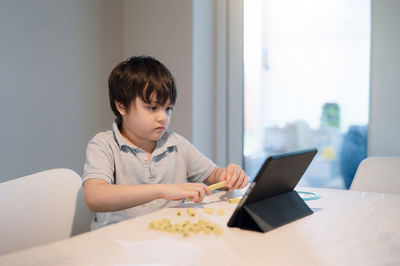 Boy sitting on table at home