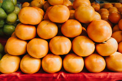 Persimmon fruits in pile at local farmers market. persimmons fruit at the farmers market