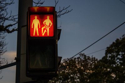 Low angle view of road sign against sky at night