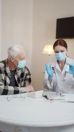 Doctor wearing mask talking with patient
