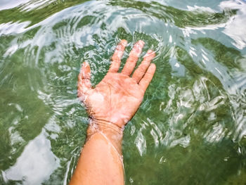 Low section of person hand in sea