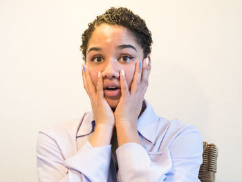 Portrait of young woman against wall