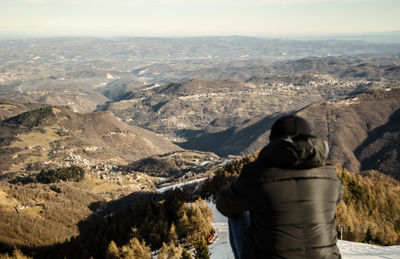 Man looking at mountains against sky