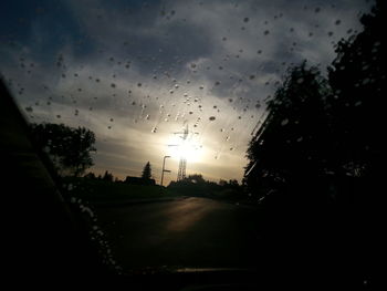 Car on road against cloudy sky at sunset