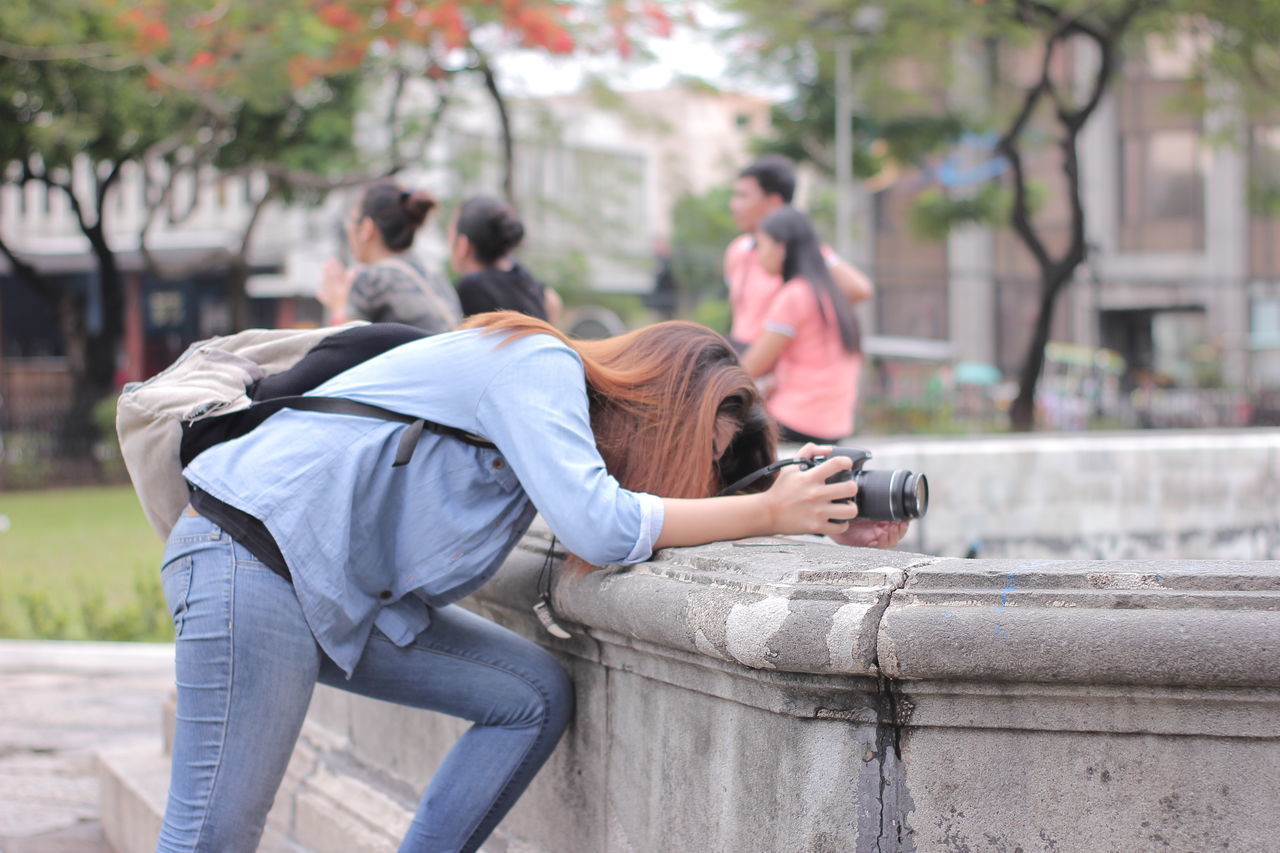 lifestyles, leisure activity, focus on foreground, men, rear view, casual clothing, togetherness, sitting, bonding, person, love, full length, day, outdoors, holding, tree, selective focus