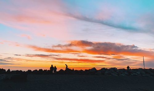 Silhouette landscape against dramatic sky during sunset