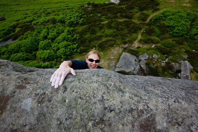 Climber topping out from a climb at stanage edge in the peak district