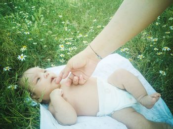 Close-up of baby lying on field