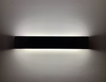 Close-up of illuminated light bulb on wall