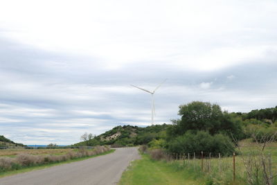 Road by field against sky