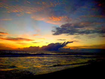 Scenic view of sea against dramatic sky during sunset