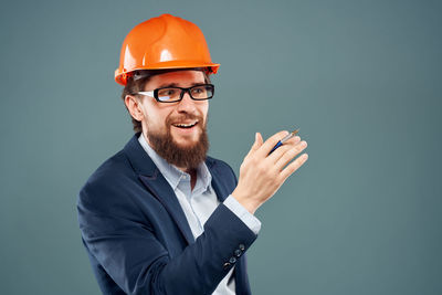 Man wearing hat standing against gray background