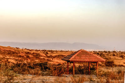 Built structure on field against sky during sunset