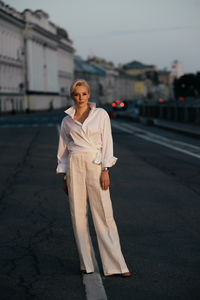 Portrait of young woman standing in city