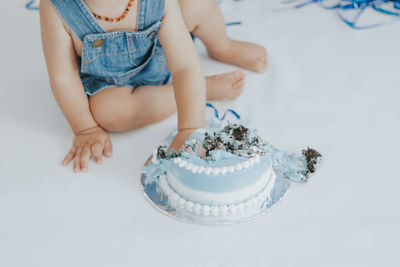 High angle view of child playing with birthday cake