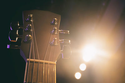 Close-up of guitar against illuminated lights