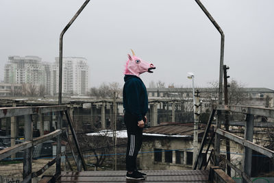 Man standing with mask against sky