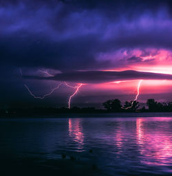 Scenic view of lightning over city at night