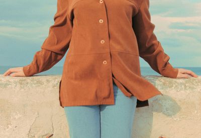 Midsection of woman standing against retaining wall