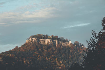 Scenic view of historical building surrounded by trees against sky