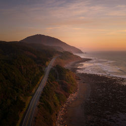 Aerial of oregon coastline and highway 101 with humbug mountain in distance at sunset