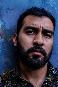 Close-up portrait of man standing against wall