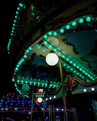 Low angle view of illuminated lighting equipment at night