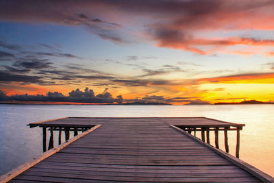 Pier over sea against sky during sunset